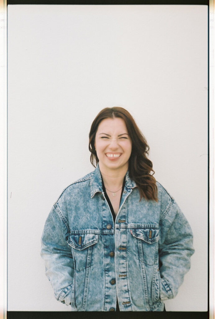 website copywriter isobel smiling in front of blank wall